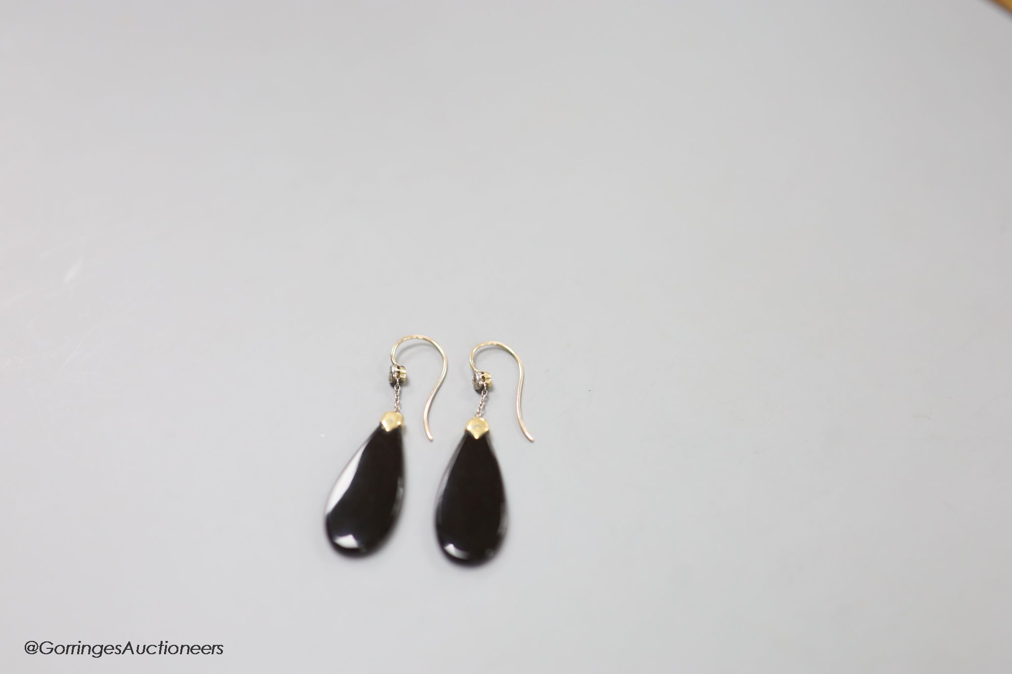 A pair of early 20th century yellow metal mounted black onyx and diamond set pear shaped drop earrings, 40mm, gross 4.6 grams.